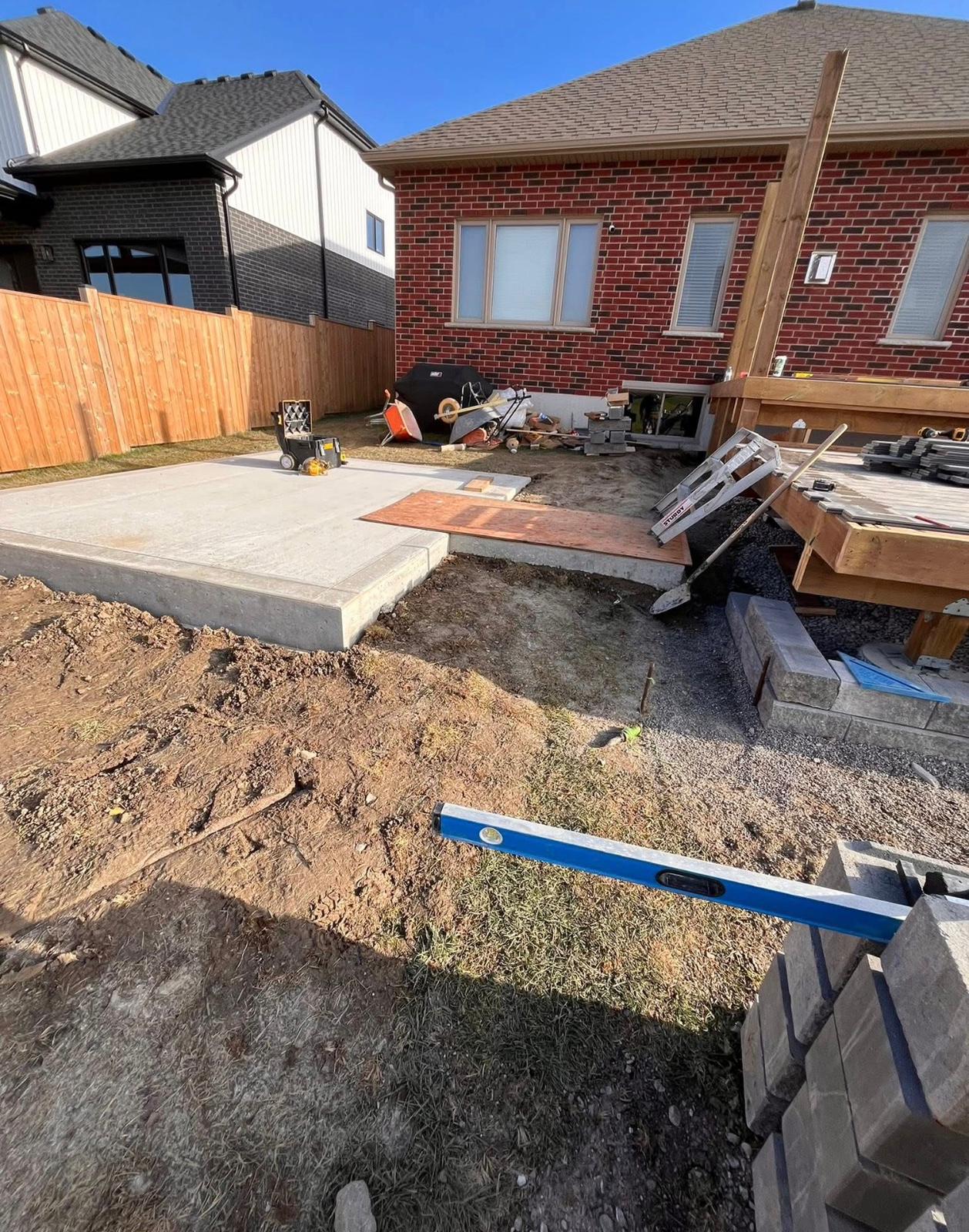 Active build site with concrete pad and deck framing by Leeonitis Contracting