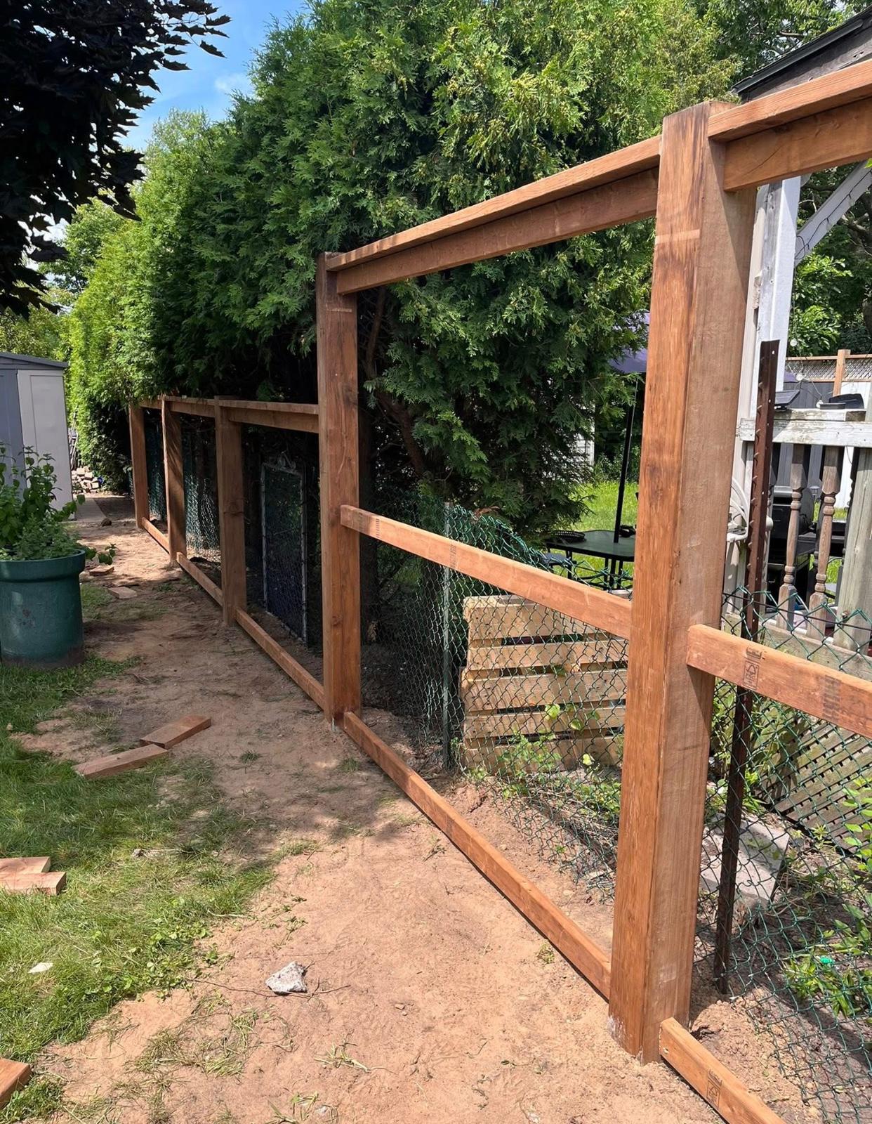 Wood frame fence with wire mesh for animal enclosure by Leeonitis Contracting