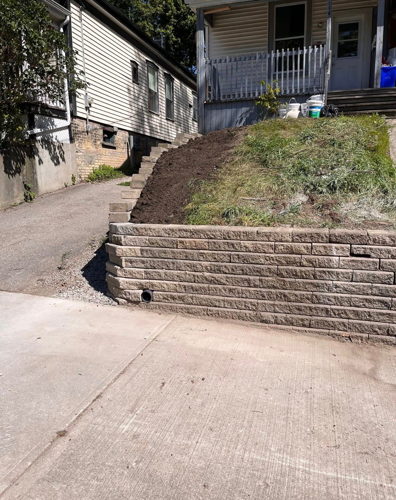 Retaining wall with stone steps on hillside by Leeonitis Contracting
